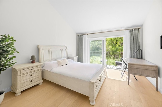 bedroom with light wood finished floors and vaulted ceiling