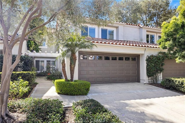 view of front of home featuring concrete driveway, a tiled roof, and stucco siding