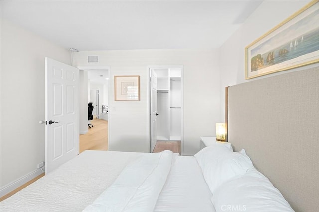 bedroom featuring wood finished floors, visible vents, and baseboards