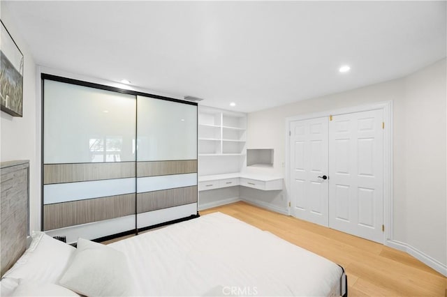 bedroom with recessed lighting, a closet, baseboards, and light wood finished floors