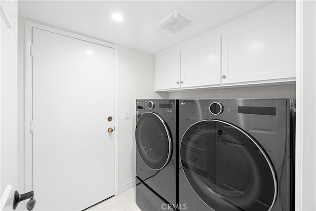 washroom featuring cabinet space, washer and clothes dryer, and light tile patterned flooring