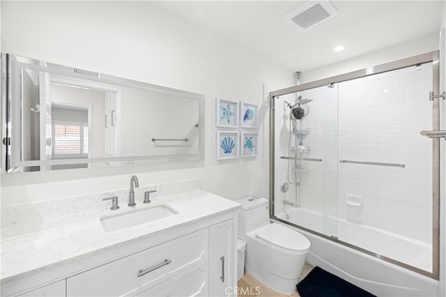 bathroom featuring visible vents, vanity, toilet, and bath / shower combo with glass door