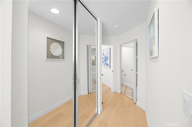 hallway with baseboards and light wood-style floors