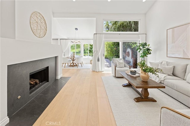 6 Baristo Unit 39, Irvine, CA 92612 - living area featuring a towering ceiling, a fireplace with flush hearth, and wood finished floors