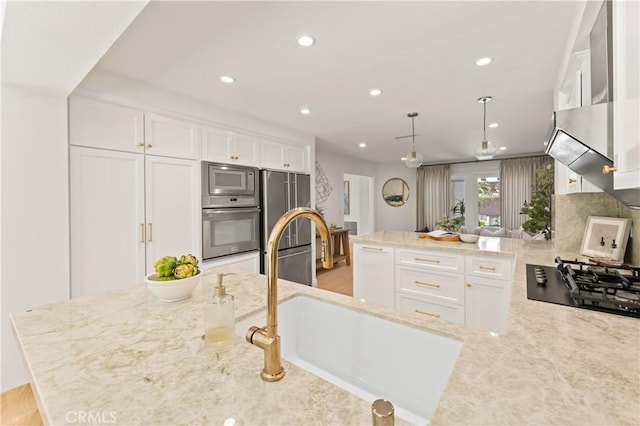 6 Baristo Unit 39, Irvine, CA 92612 - kitchen with appliances with stainless steel finishes, a sink, white cabinetry, light stone countertops, and recessed lighting