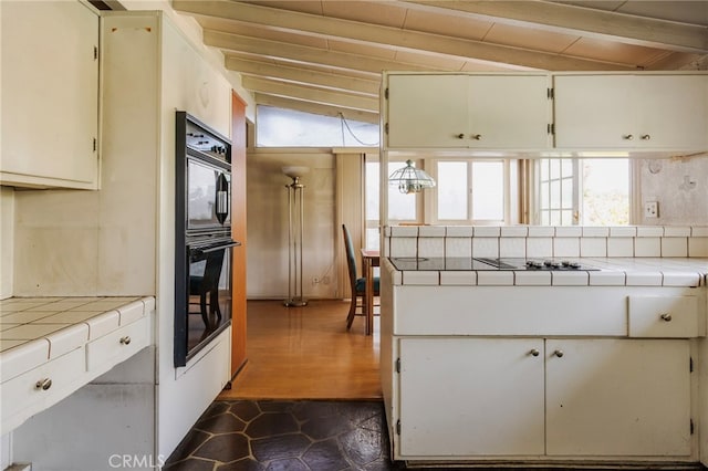 kitchen with tile countertops, black appliances, tasteful backsplash, and white cabinetry