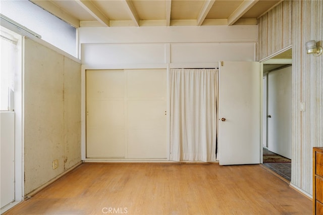 unfurnished bedroom with a closet and light wood-style flooring