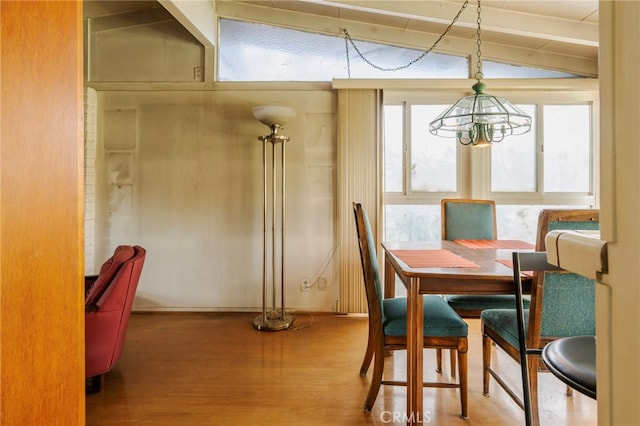 dining room featuring lofted ceiling, an inviting chandelier, and wood finished floors