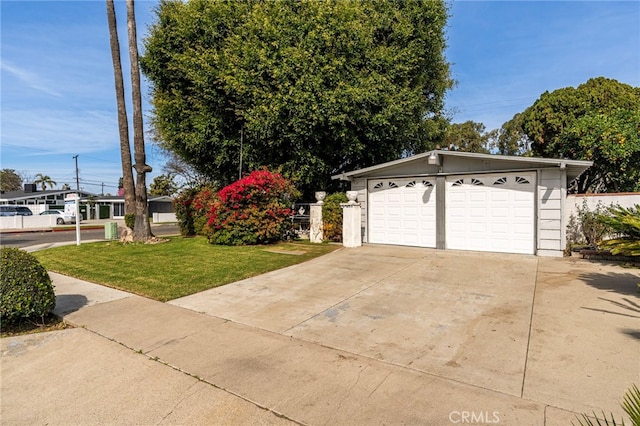 exterior space featuring a garage, an outbuilding, and a front yard