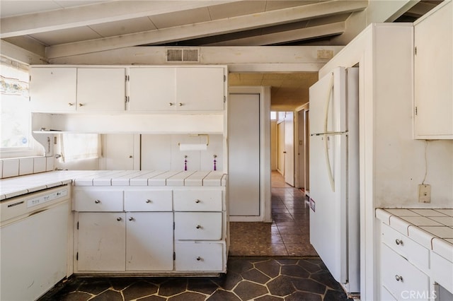 kitchen featuring tile countertops, white appliances, lofted ceiling with beams, and visible vents