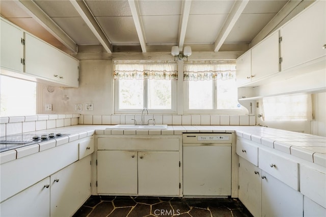 kitchen featuring a healthy amount of sunlight, dishwasher, tile countertops, and a sink