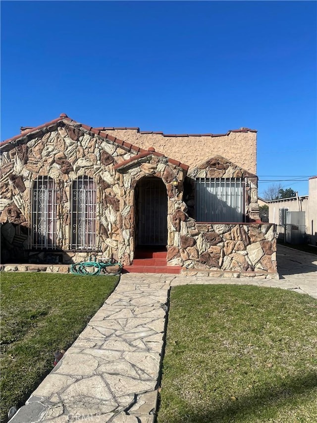 view of front of property featuring stone siding and a front yard