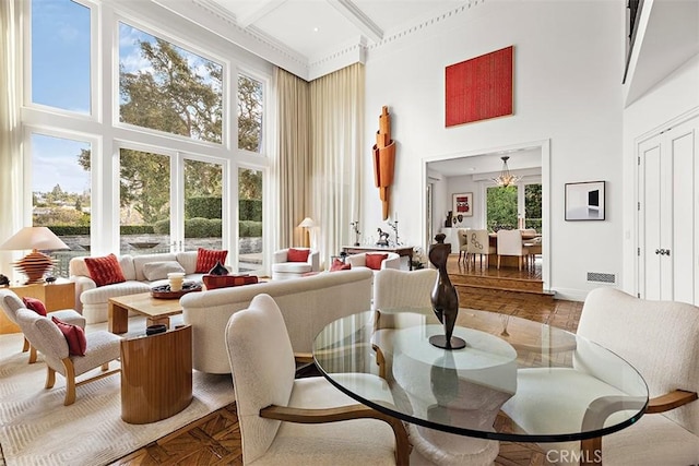 interior space with coffered ceiling, visible vents, a towering ceiling, baseboards, and beam ceiling