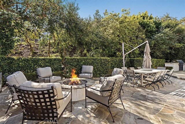 view of patio with an outdoor fire pit, outdoor dining area, a grill, and fence