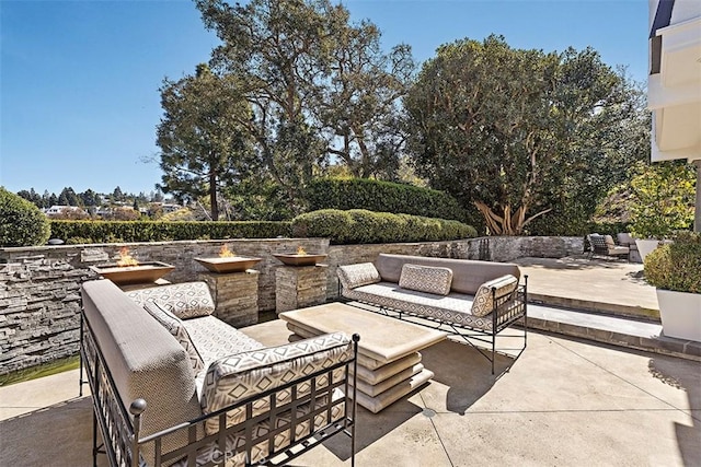 view of patio featuring an outdoor living space with a fire pit