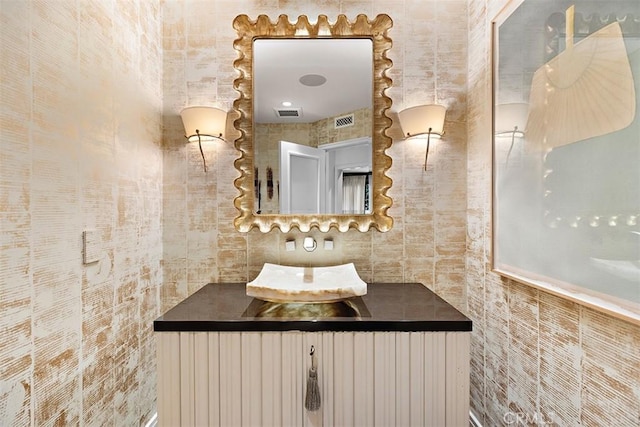 bathroom featuring visible vents and tile walls