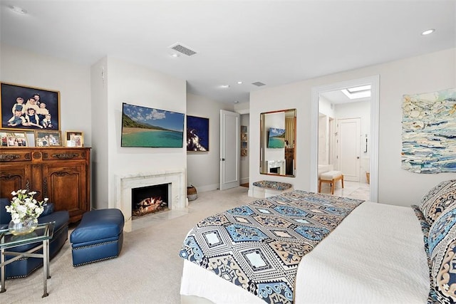 carpeted bedroom with recessed lighting, visible vents, connected bathroom, and a high end fireplace
