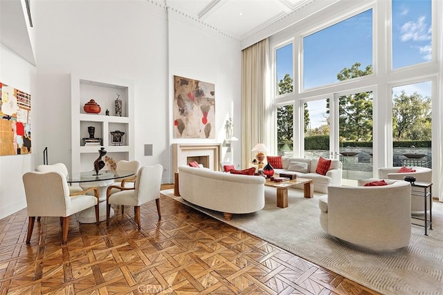 interior space featuring a towering ceiling, built in shelves, and a fireplace