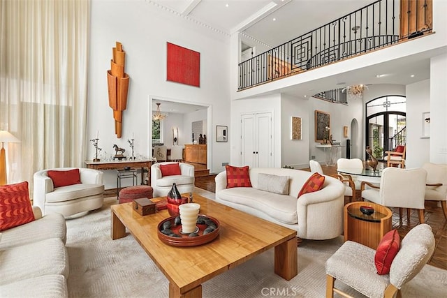 living area with arched walkways, a towering ceiling, and an inviting chandelier