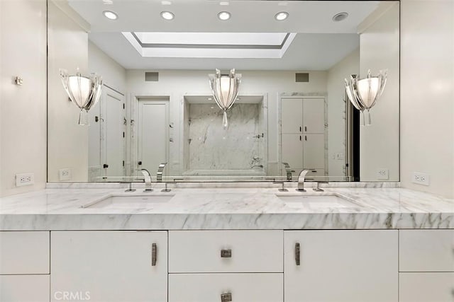 bathroom featuring double vanity, a skylight, and a sink