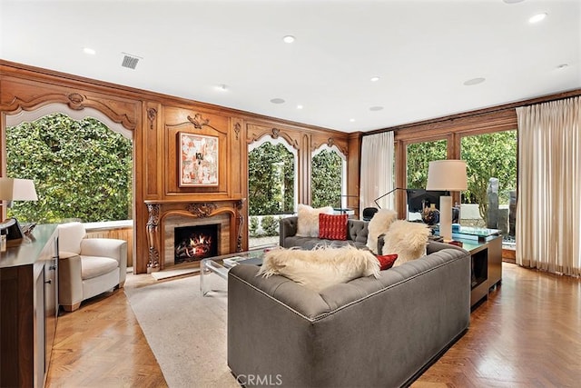living room with recessed lighting, visible vents, and a premium fireplace