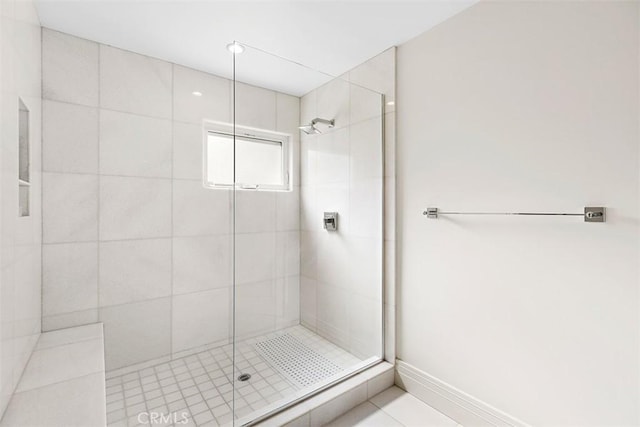 bathroom with a shower stall and baseboards