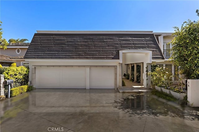 view of property featuring driveway, an attached garage, and stucco siding