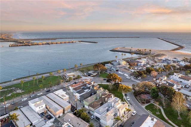 aerial view at dusk featuring a water view