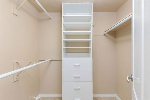 walk in closet with light tile patterned floors