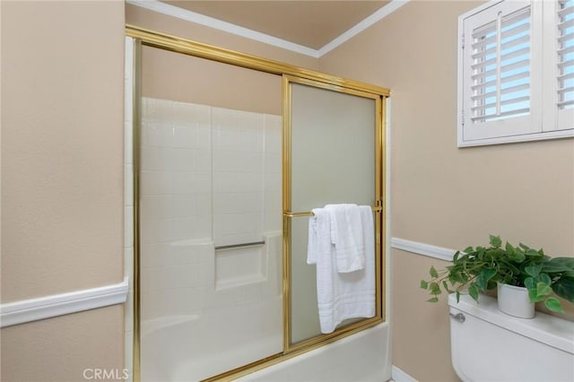 bathroom featuring ornamental molding, shower / bath combination with glass door, and toilet