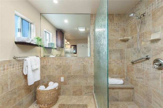 bathroom with a stall shower, recessed lighting, tile walls, and a wainscoted wall