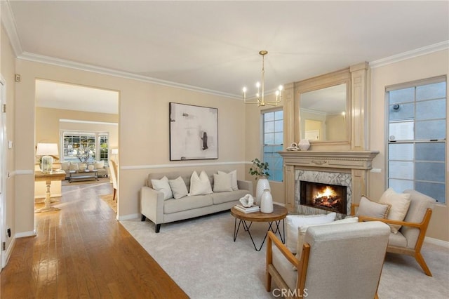 living area with a premium fireplace, baseboards, and crown molding