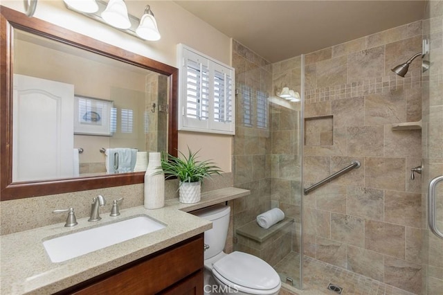 full bathroom with toilet, a shower stall, and vanity