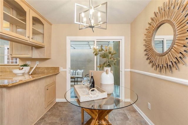 dining space with a chandelier and baseboards