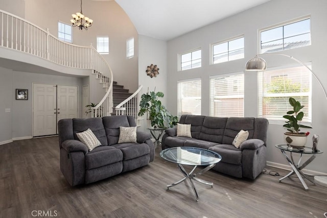 living area featuring plenty of natural light, stairway, baseboards, and wood finished floors