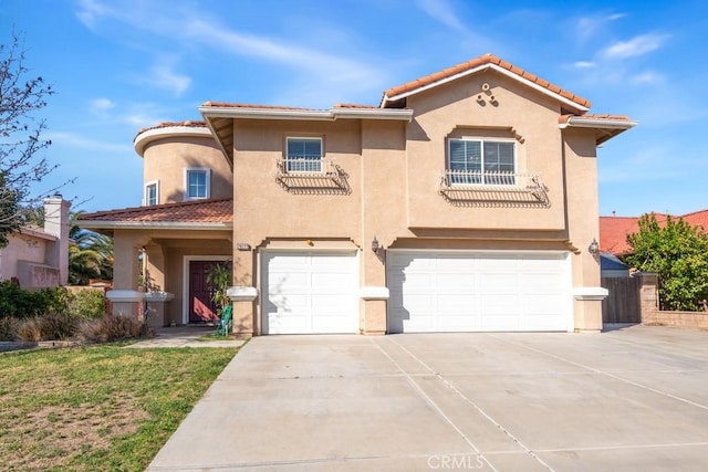 mediterranean / spanish-style home with driveway, a tiled roof, an attached garage, and stucco siding