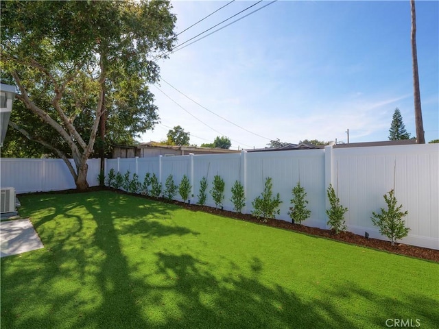 view of yard with central AC unit and a fenced backyard