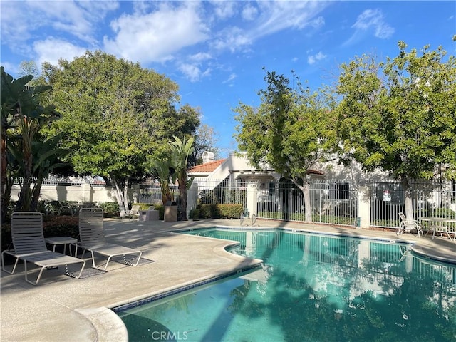 pool with a patio and fence