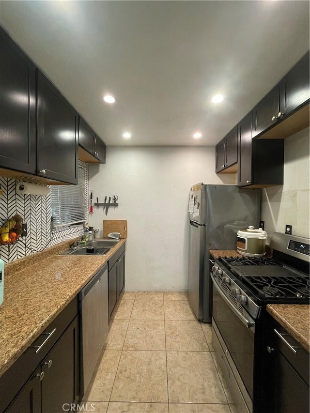 kitchen featuring light tile patterned floors, decorative backsplash, appliances with stainless steel finishes, a sink, and recessed lighting