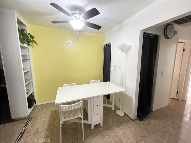 unfurnished office with ceiling fan, a textured ceiling, light tile patterned flooring, and baseboards