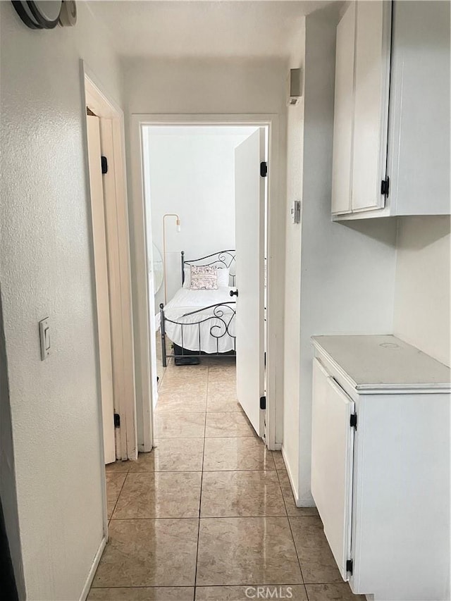 hallway with baseboards and light tile patterned floors