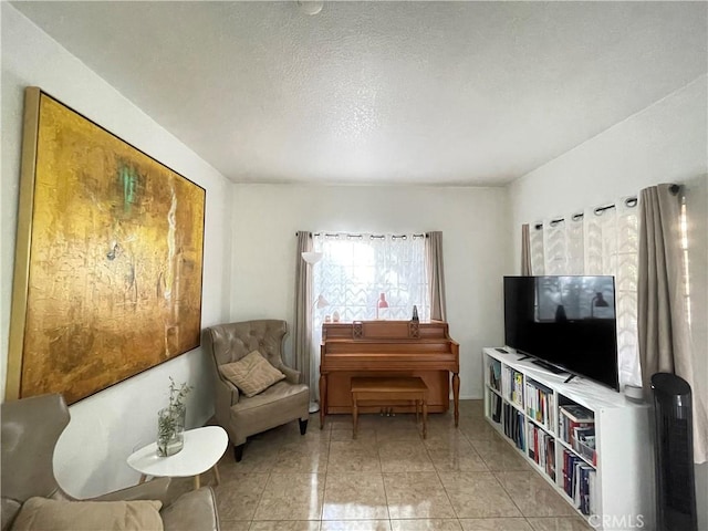 sitting room featuring a textured ceiling and light tile patterned flooring