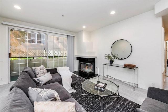 living area featuring baseboards, a multi sided fireplace, and recessed lighting