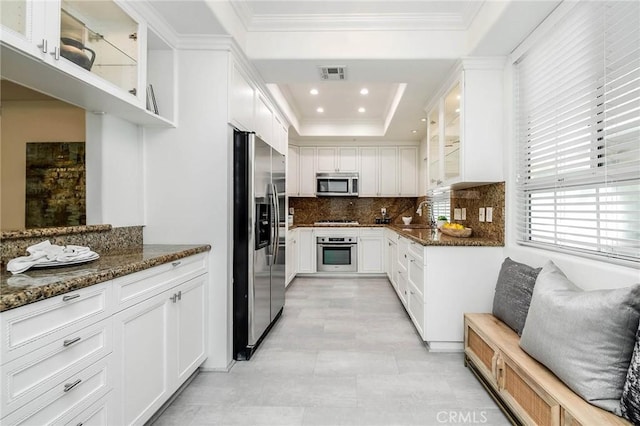 kitchen with a tray ceiling, ornamental molding, visible vents, and stainless steel appliances