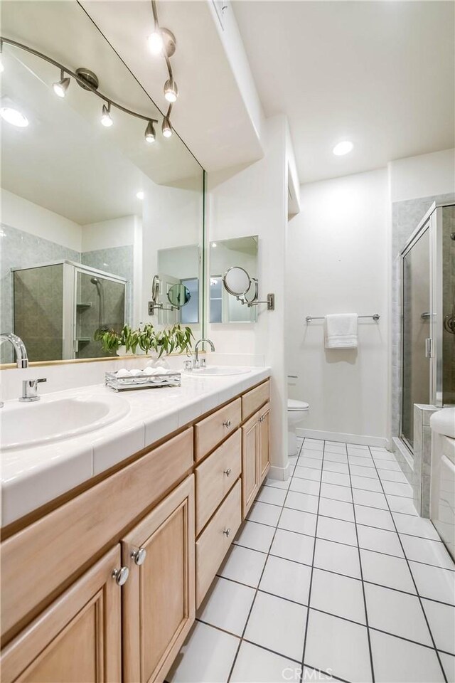 full bathroom with tile patterned floors, toilet, a shower stall, and a sink