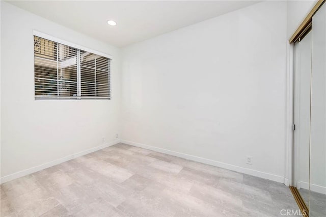 unfurnished room featuring recessed lighting, baseboards, and light wood-style flooring