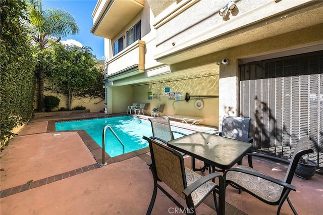 view of swimming pool with outdoor dining area, a patio area, and a fenced in pool