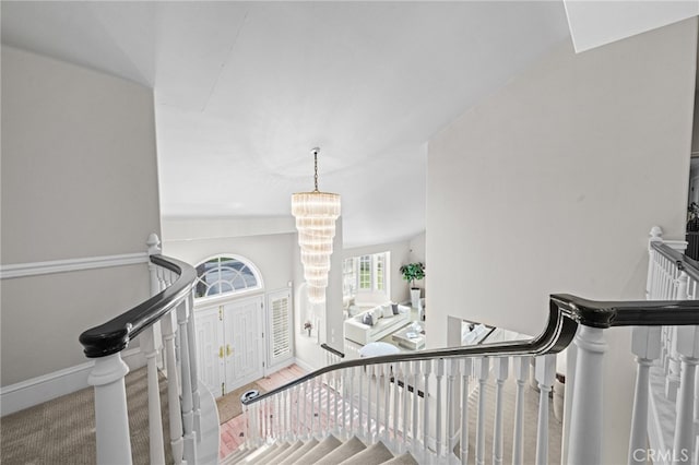 stairs with a chandelier and baseboards