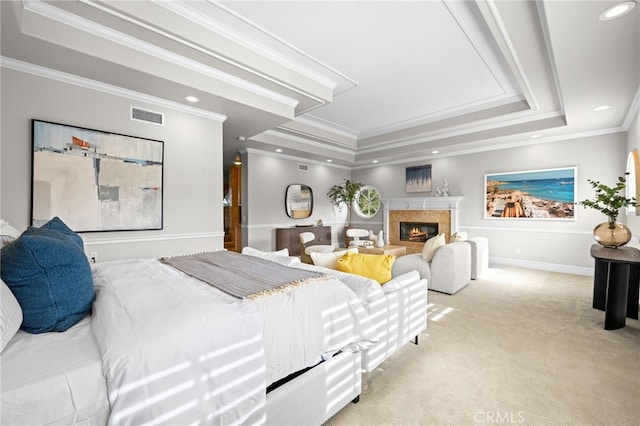 bedroom with carpet, visible vents, a tray ceiling, recessed lighting, and a high end fireplace