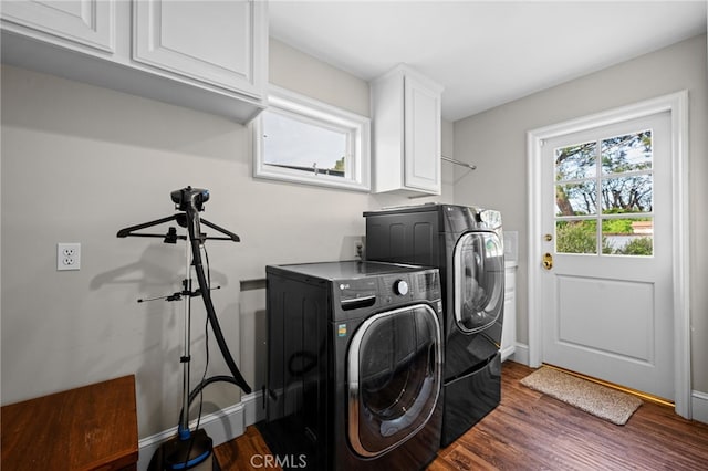 laundry area with washer and dryer, baseboards, cabinet space, and wood finished floors